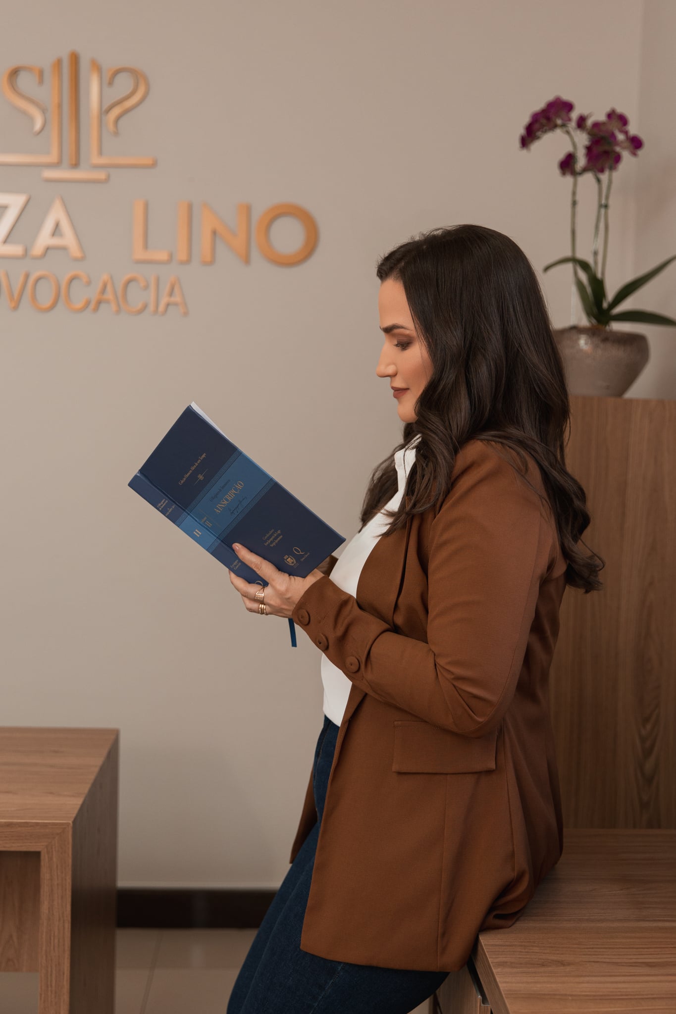 Dayse de Souza Lino lendo livro jurídico no escritório